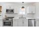 Modern kitchen boasts stainless appliances, white cabinetry, and stylish pendant lighting at 4503 Overbrook Ave, North Charleston, SC 29405