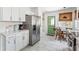 Eat-in kitchen features stainless refrigerator, white cabinets, and a charming green door at 4503 Overbrook Ave, North Charleston, SC 29405