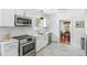 Bright, updated kitchen features stainless steel appliances, white cabinets, and marble-look tile flooring at 4503 Overbrook Ave, North Charleston, SC 29405