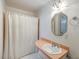 Compact bathroom featuring a single sink vanity with a pink countertop and a bathtub with a white shower curtain at 4942 Storage Rd, Meggett, SC 29449