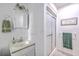 Bright bathroom featuring a single sink vanity, framed mirror, and a shower with sliding glass doors at 4942 Storage Rd, Meggett, SC 29449