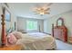 Comfortable bedroom features a four-poster bed, ceiling fan, and matching dresser, offering a serene and traditional retreat at 4942 Storage Rd, Meggett, SC 29449