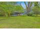 Exterior view of a house featuring a screened porch and beautiful landscaping with vibrant greenery at 4942 Storage Rd, Meggett, SC 29449