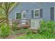 Exterior showcasing a small wooden deck with vibrant flowers and a backup generator at 4942 Storage Rd, Meggett, SC 29449