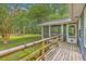 Lovely deck showing the entrance to the screened porch surrounded by lush green grass at 4942 Storage Rd, Meggett, SC 29449