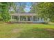 Charming one-story home featuring a cozy front porch and well-maintained lawn at 4942 Storage Rd, Meggett, SC 29449