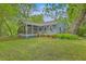 Beautiful home with a screened porch and wood railing, surrounded by lush greenery at 4942 Storage Rd, Meggett, SC 29449