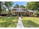 Stately brick two-story home featuring a welcoming front porch and meticulously landscaped front yard at 501 Willow Branch Way, Mount Pleasant, SC 29464