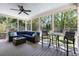 Inviting screened porch featuring comfortable seating, ceiling fan, and wooded backyard views at 501 Willow Branch Way, Mount Pleasant, SC 29464
