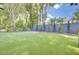 Large backyard with putting green, privacy fence, and mature trees is ideal for outdoor activities at 5029 Victoria Ave, North Charleston, SC 29405