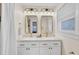Bright bathroom featuring double sinks, modern fixtures, ample lighting, and a large mirror with framed edges at 5029 Victoria Ave, North Charleston, SC 29405