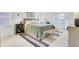 Bright bedroom featuring a large bed with an upholstered headboard and woven bench at the end of the bed at 5029 Victoria Ave, North Charleston, SC 29405