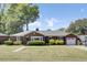 Charming brick home with well-maintained landscaping, a driveway, and an attached garage at 5029 Victoria Ave, North Charleston, SC 29405