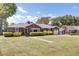 Beautiful brick home with a lush green lawn, mature trees, and an attached garage at 5029 Victoria Ave, North Charleston, SC 29405