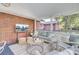 Inviting screened-in porch features a brick wall, TV, comfortable seating, and stylish decor at 5029 Victoria Ave, North Charleston, SC 29405