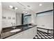 A modern bathroom featuring double sinks, dark granite countertops, and a free-standing tub with black and white tiling at 517 King St # 13, Charleston, SC 29403