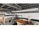 A creatively designed bedroom with a desk, soft lighting, and industrial-style exposed ceiling and duct work at 517 King St # 13, Charleston, SC 29403