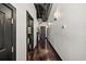 Long hallway featuring dark wood floors, black door frames, modern lighting, and an exposed ceiling at 517 King St # 13, Charleston, SC 29403