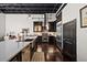 A beautifully appointed kitchen featuring dark cabinets, a stainless steel island sink, and an exposed ceiling at 517 King St # 13, Charleston, SC 29403