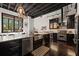 Modern kitchen featuring black cabinetry, stainless steel appliances, island, and adjacent seating area by a large window at 517 King St # 13, Charleston, SC 29403