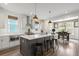 Modern kitchen with white cabinets, a gray island, and view into the dining area at 518 Sound Dr, Summerville, SC 29486