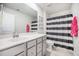 Modern bathroom features a gray vanity with white countertop and a shower-tub combination with a striped curtain at 533 Richfield Way, Summerville, SC 29486