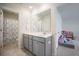 Well-lit bathroom features a gray vanity with a white countertop, with a view of the bathtub and an open view into a bedroom at 533 Richfield Way, Summerville, SC 29486