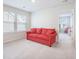 Bright bonus room with a comfortable red sofa and plenty of natural light from large windows at 533 Richfield Way, Summerville, SC 29486