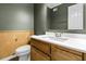 Bathroom featuring a wood vanity, square mirror, and paneled walls at 5737 Dewsbury Ln, North Charleston, SC 29418