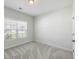 Well-lit bedroom featuring a window offering neighborhood views, neutral walls, and plush carpeting at 603 Yellow Leaf Ln, Summerville, SC 29486
