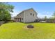 Spacious backyard with lush green grass, a firepit, and outdoor seating area at 606 Knowledge Dr, Ladson, SC 29456