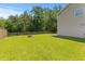 Large backyard with a firepit, wood fence, and manicured lawn at 606 Knowledge Dr, Ladson, SC 29456