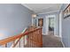 Hallway with wood railing and carpet, leading to rooms filled with natural light at 606 Knowledge Dr, Ladson, SC 29456