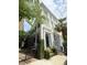 Charming multi-story home boasts detailed trim, a black front door, and an intricate gated brick walkway at 62 Society St, Charleston, SC 29401