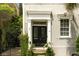 Exterior shot of a charming home with a black front door and verdant landscaping at 62 Society St, Charleston, SC 29401