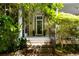 Stairs leading to a front porch framed by lush landscaping and a glass-paneled door at 62 Society St, Charleston, SC 29401
