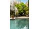 Enjoy an outdoor living space with a dining area and an in-ground pool surrounded by mature trees and landscaping at 62 Society St, Charleston, SC 29401