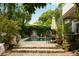 Enjoy outdoor living with an in-ground pool, dining area, beautiful lush landscaping, and mature trees at 62 Society St, Charleston, SC 29401
