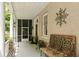 Covered porch with seating, ornamental decor and view of surrounding greenery at 62 Society St, Charleston, SC 29401
