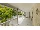 Spacious porch with white railings, columns, and lush greenery views at 62 Society St, Charleston, SC 29401