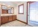 Bathroom featuring a wood vanity with double sinks and a large mirror and a wooden door at 625 Ocean Blvd, Isle of Palms, SC 29451