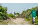 Sandy beach access path, lush greenery, and signage marking the beach rules and boundaries at 625 Ocean Blvd, Isle of Palms, SC 29451