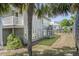 Home exterior featuring a balcony, palms, lush greenery, and a light gray facade at 625 Ocean Blvd, Isle of Palms, SC 29451