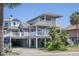 Charming home with a covered boat/car port, multiple balconies, and lush tropical landscaping at 625 Ocean Blvd, Isle of Palms, SC 29451