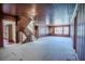 Large living room with wood paneling, carpet flooring, staircase, and windows overlooking the neighborhood at 625 Ocean Blvd, Isle of Palms, SC 29451