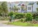 Street view of white facade homes with palm trees, verdant landscaping, green grass, and beach access at 625 Ocean Blvd, Isle of Palms, SC 29451