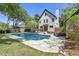 Backyard with a pool and a well-maintained, grassy lawn and a white house at 699 Castle Pinckney Dr, James Island, SC 29412