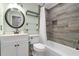 Well-lit bathroom with a bathtub and shower combination, round mirror, and a white vanity with drawers for storage at 699 Castle Pinckney Dr, James Island, SC 29412