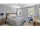 Bright bedroom with two windows, a ceiling fan, carpeted floors, and a bed with a gray headboard and blue comforter at 699 Castle Pinckney Dr, James Island, SC 29412