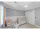 A bright Bedroom with neutral grey walls, a crib, and a large window at 699 Castle Pinckney Dr, James Island, SC 29412